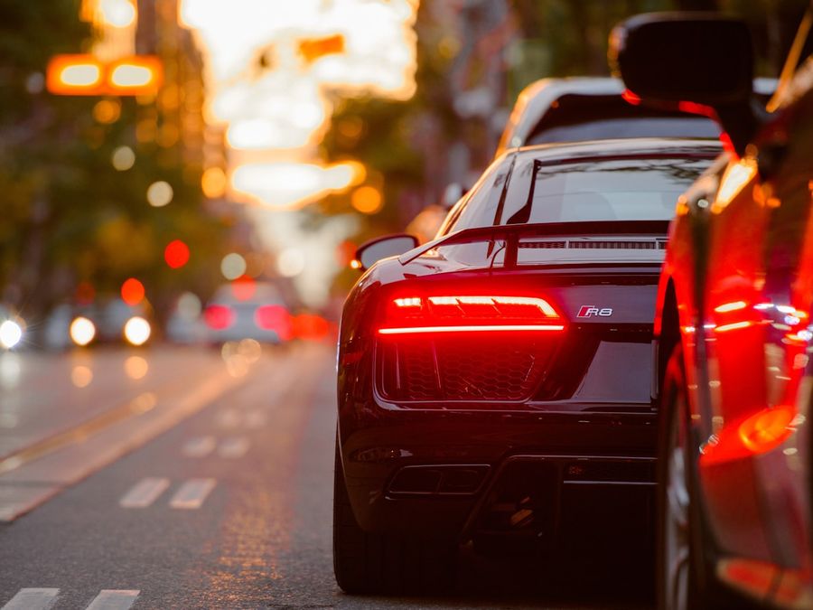 Glossy taillight and body panel of a repaired car at dusk
